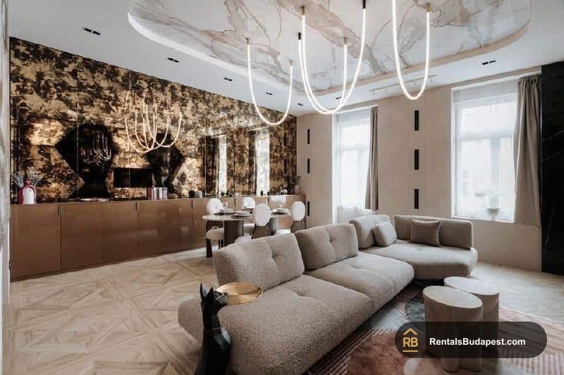 Open living room with marble ceiling, bronze-patterned feature wall, beige boucle sofas, and sculptural white pendant lights