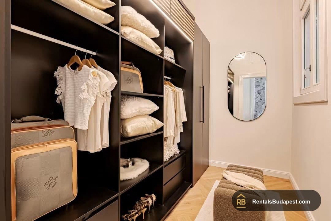 Walk-in wardrobe with folded linens, hanging blouses, designer luggage and shoes, Falk Miksa utca