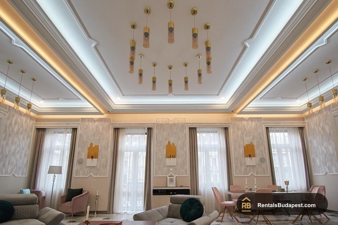 Living room with coffered ceiling, glass pendant lights and tall curtained windows above grey sofas, Szent István körút