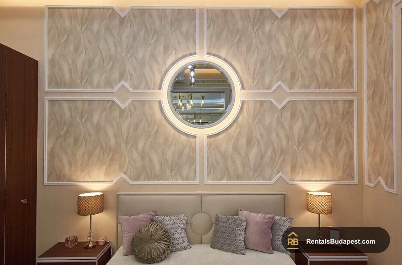 Bedroom with round backlit mirror above bed, lamps flanking, Szent István körút