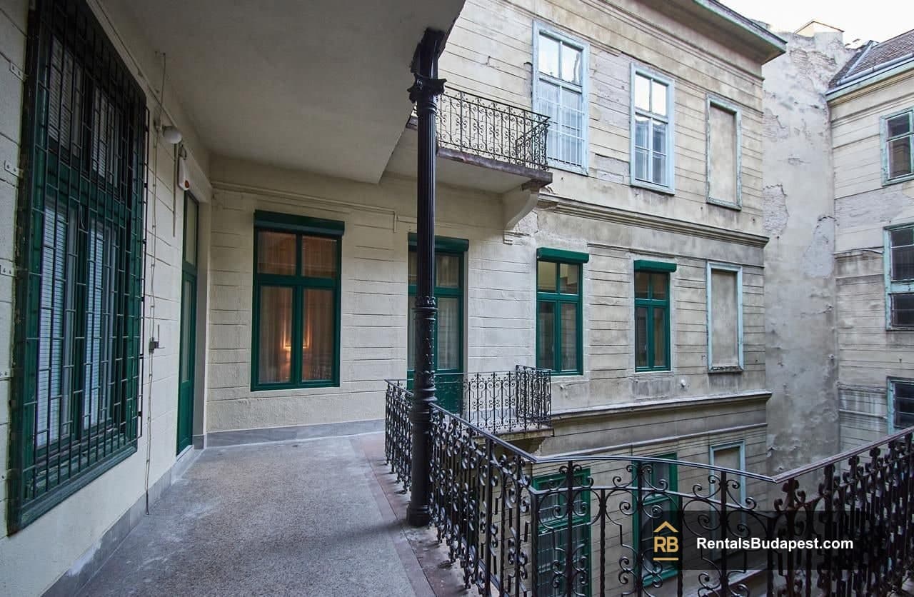 Covered balcony with wrought iron railing overlooking courtyard of historic building, Szent István körút