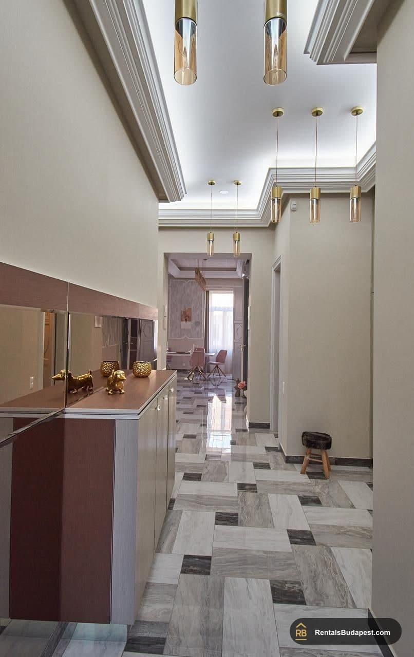 Hallway with marble-look tiled floor, gold pendant lights and sideboard, Szent István körút