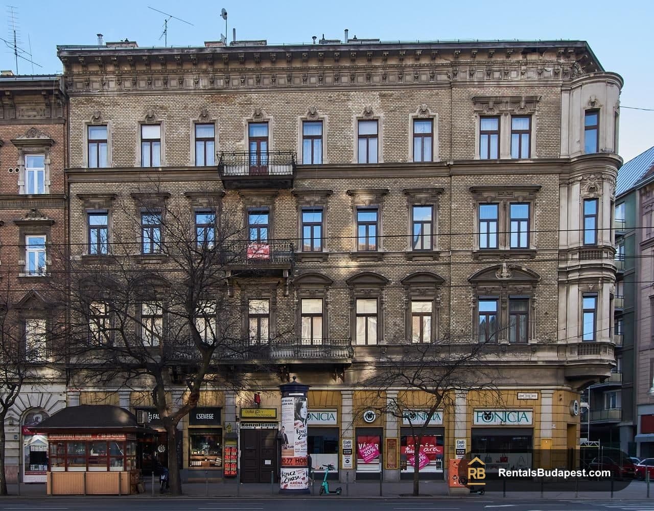 Ornate multi-storey brick facade with balconies and ground-floor shops, Szent István körút