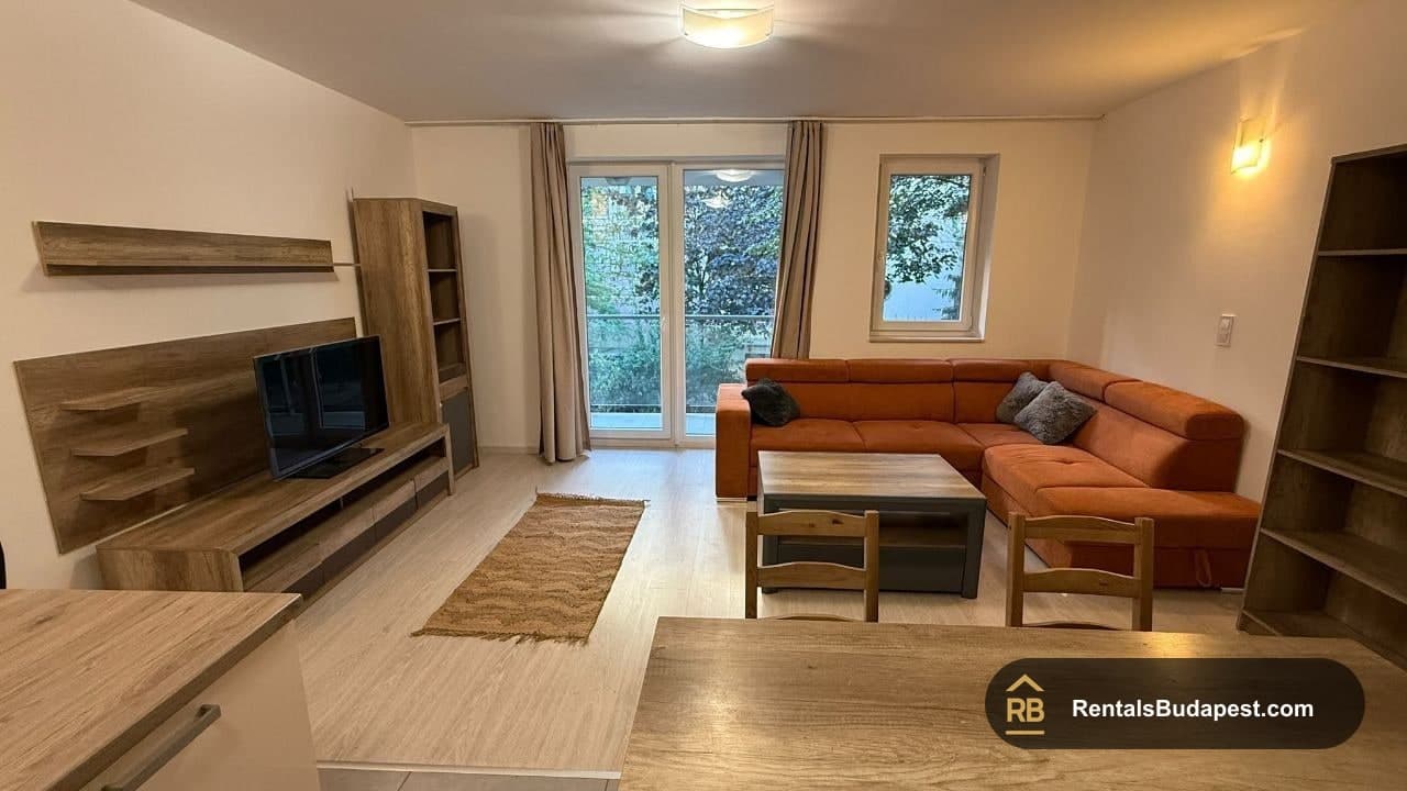 Living room with orange corner sofa, TV unit, dining chairs and balcony doors, Viola utca