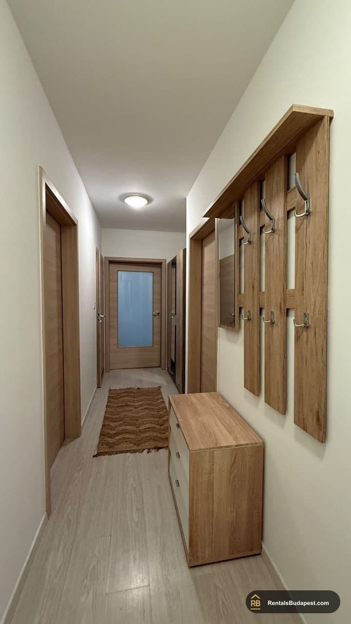 Hallway with wall coat hooks, wooden shoe cabinet and several interior doors, Viola utca